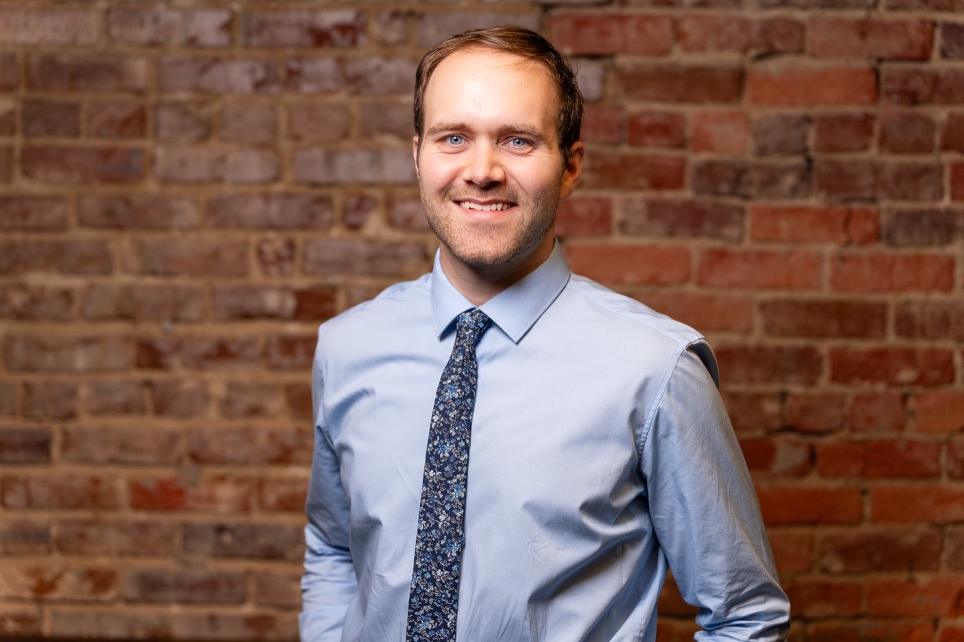 Andrew Harrell, landscape architect, in front of a brick wall